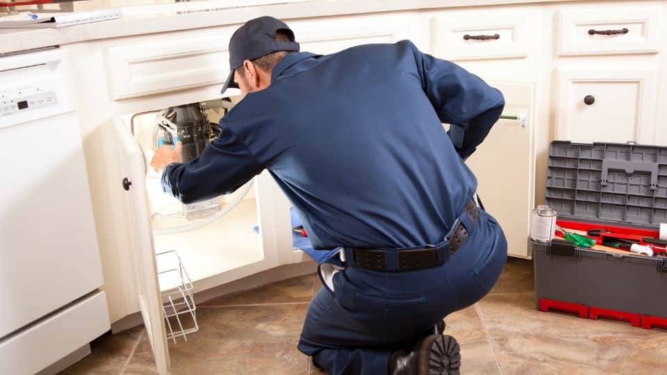 Plumber working under kitchen sink