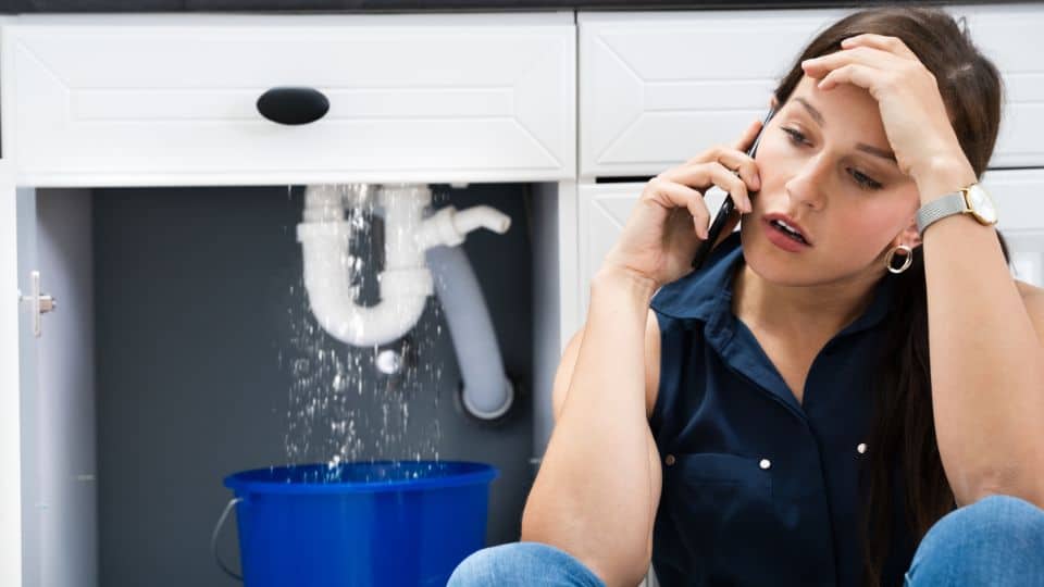 Woman with pipe burst calling Plumber