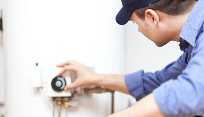 Technician Adjusting Water Heater Technician Adjusting Water Heater